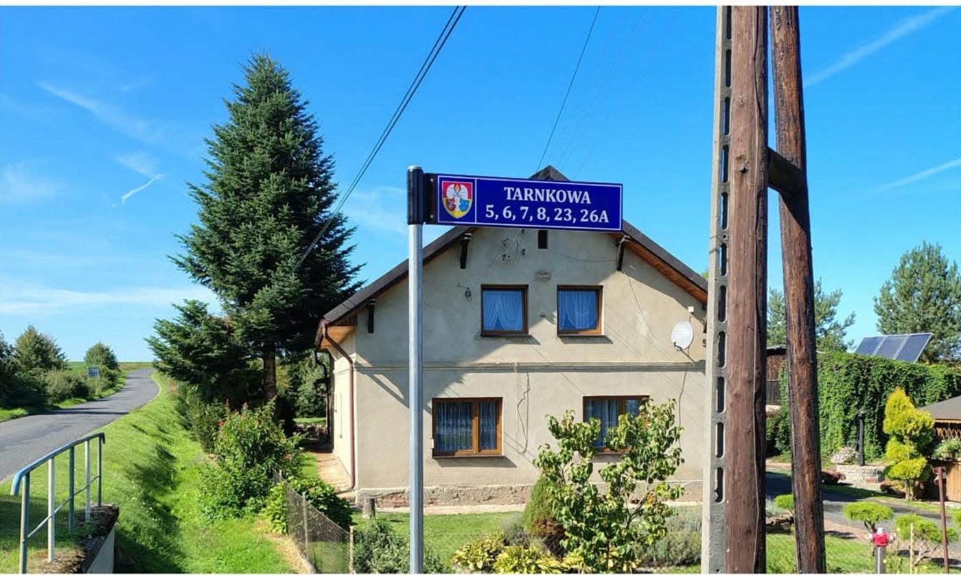 Nowy znak z nazwą Tarnkowa i numerami posesji przy drodze we wsi